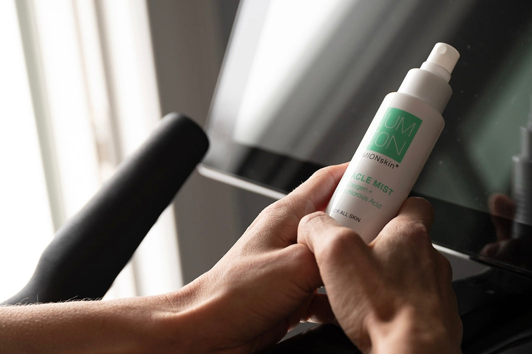 Women on an excercise bike hold LUMION Skin Miracle Mist in her hands. 
