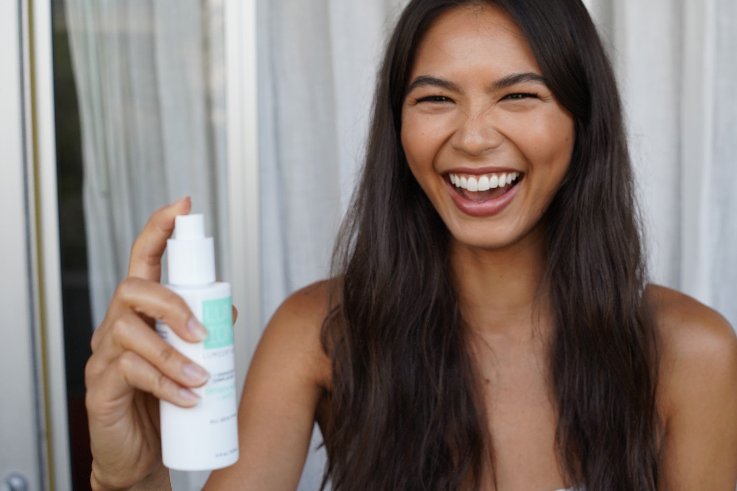 Woman holding Lumion skincare product